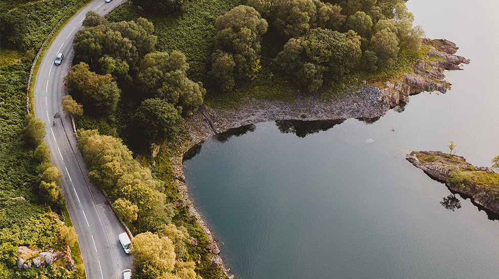 Aerial shot of a winding road by the coast
